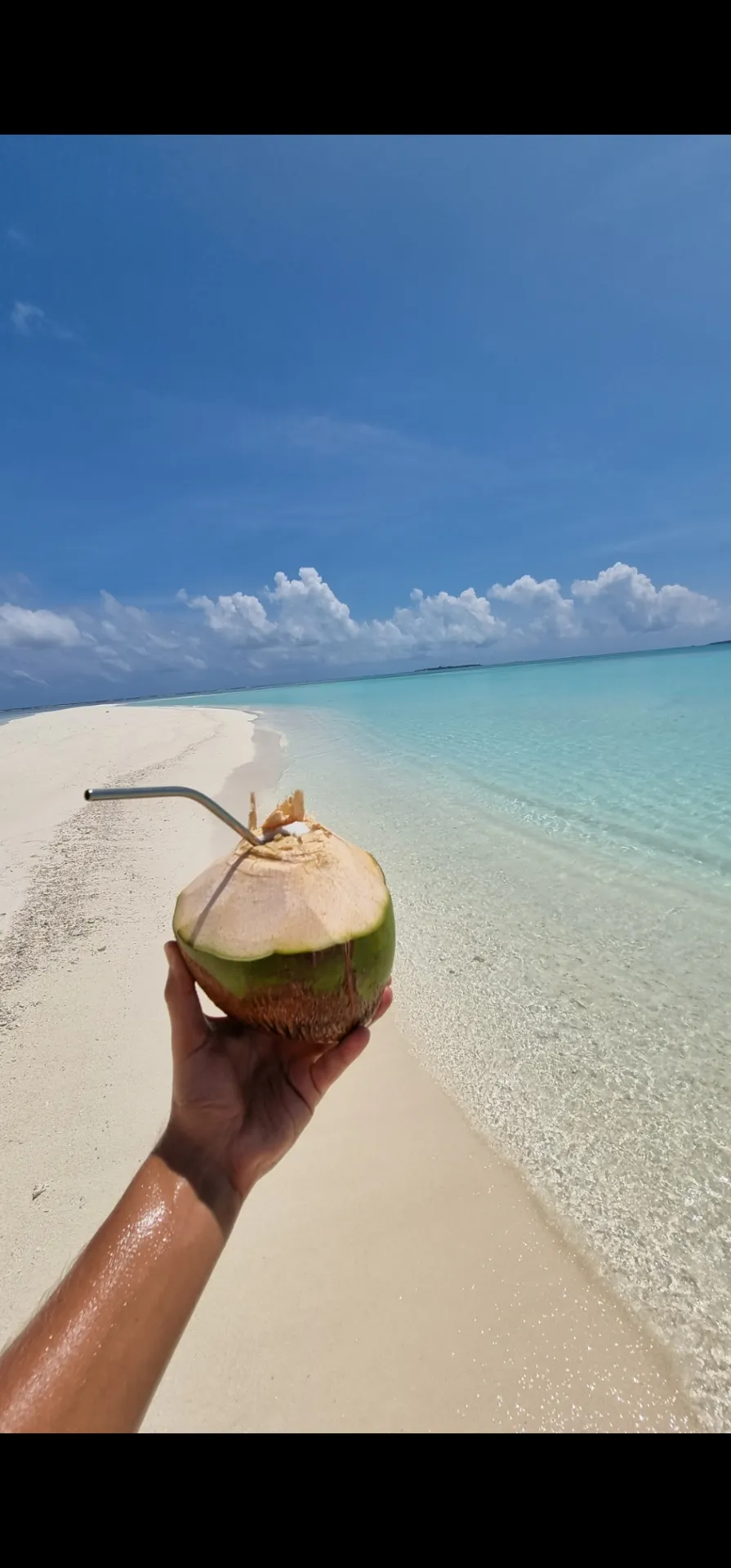 White sandbank and excursion boat in a turquoise lagoon